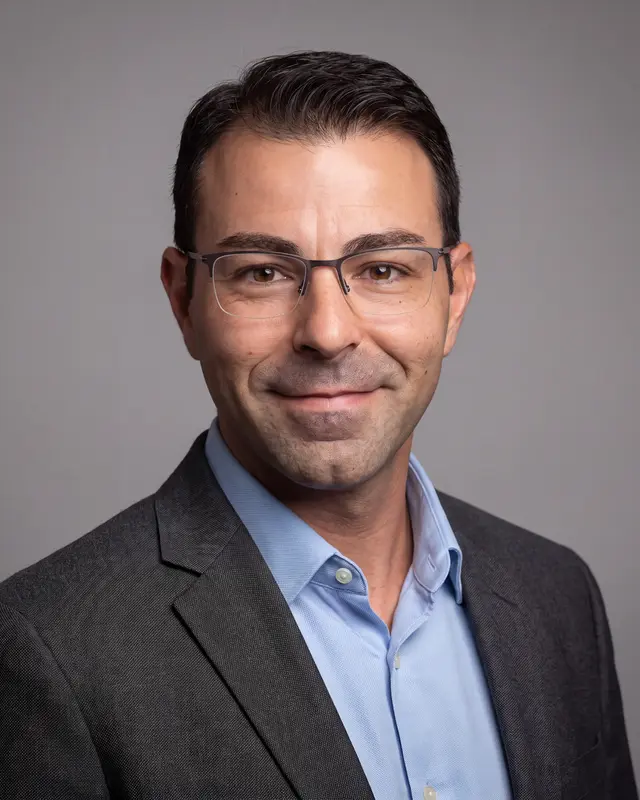 AI example made from that selfie: the same man in a charcoal blazer on a gray background