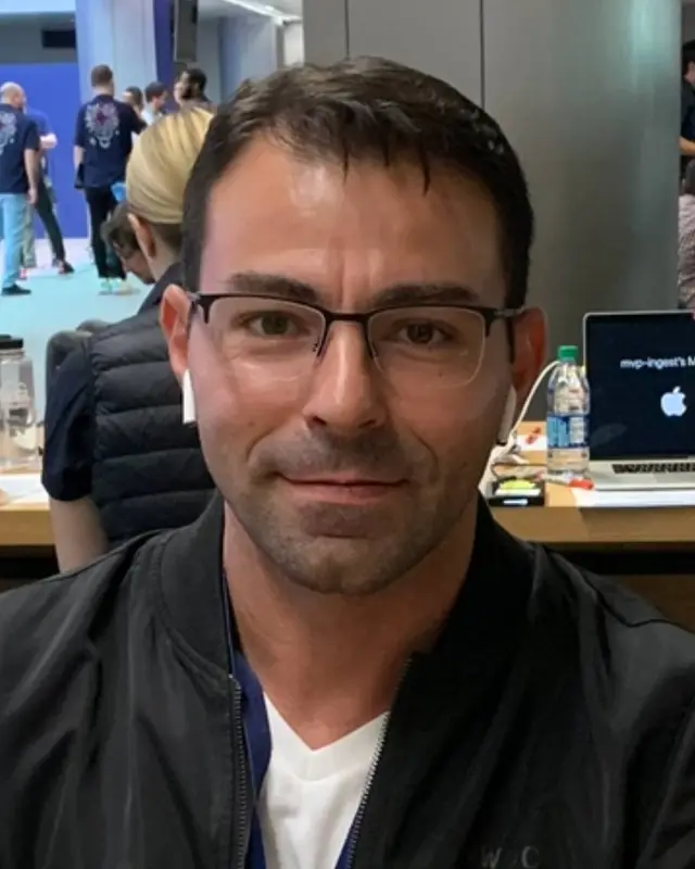 Original selfie: a man with glasses at a busy event