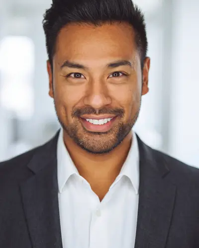 AI example made from that photo: the same man in a charcoal suit in an office