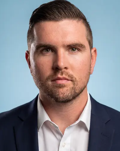 AI example made from that photo: the same man in a navy suit on a blue background