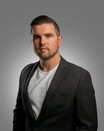 Original photo: a man in a dark blazer on a gray background