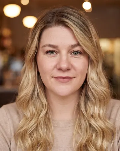 AI example made from that photo: the same woman in a beige sweater in a cafe with warm lights