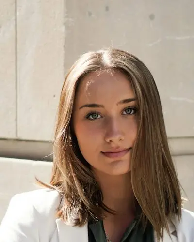 Original photo: a young woman in a white blazer by a building