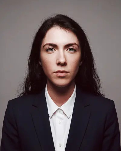 AI example made from that photo: the same woman in a black suit on a gray background