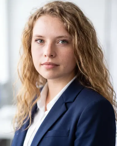 AI example made from that photo: the same woman in a navy blazer in a bright room