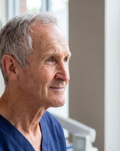 AI example made from that photo: the same man in navy scrubs in a bright clinic