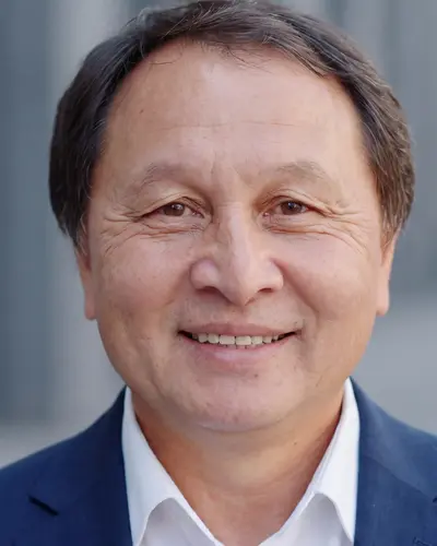 AI example made from that photo: the same man in a navy suit against a blurred background